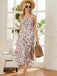 Woman in a floral dress and straw hat standing in a bright room with large windows.