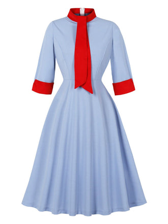 Robe bleue col montant et nœud contrastant années 1950