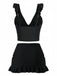 Black two-piece outfit with ruffled top and skirt on a white background