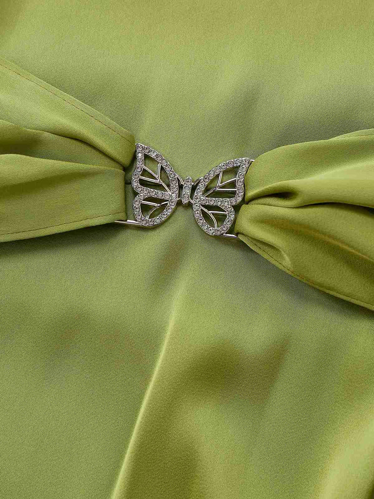 Green fabric with a butterfly-shaped brooch