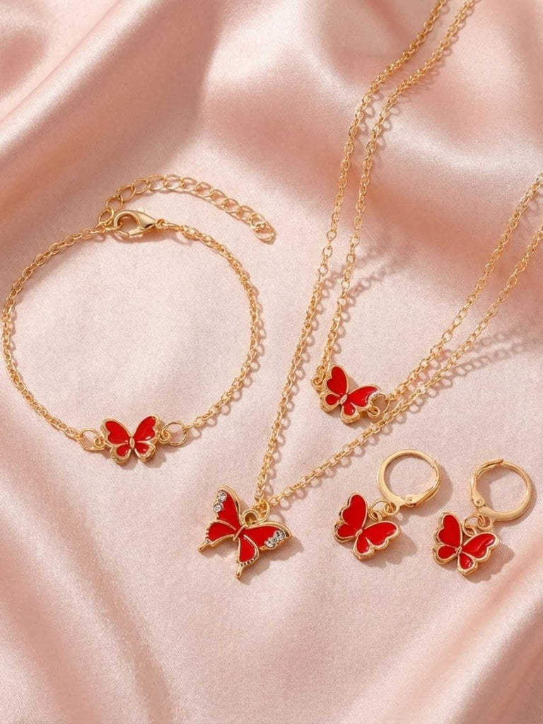 Ensemble de bijoux en or avec des breloques papillon roses sur un fond en tissu rose