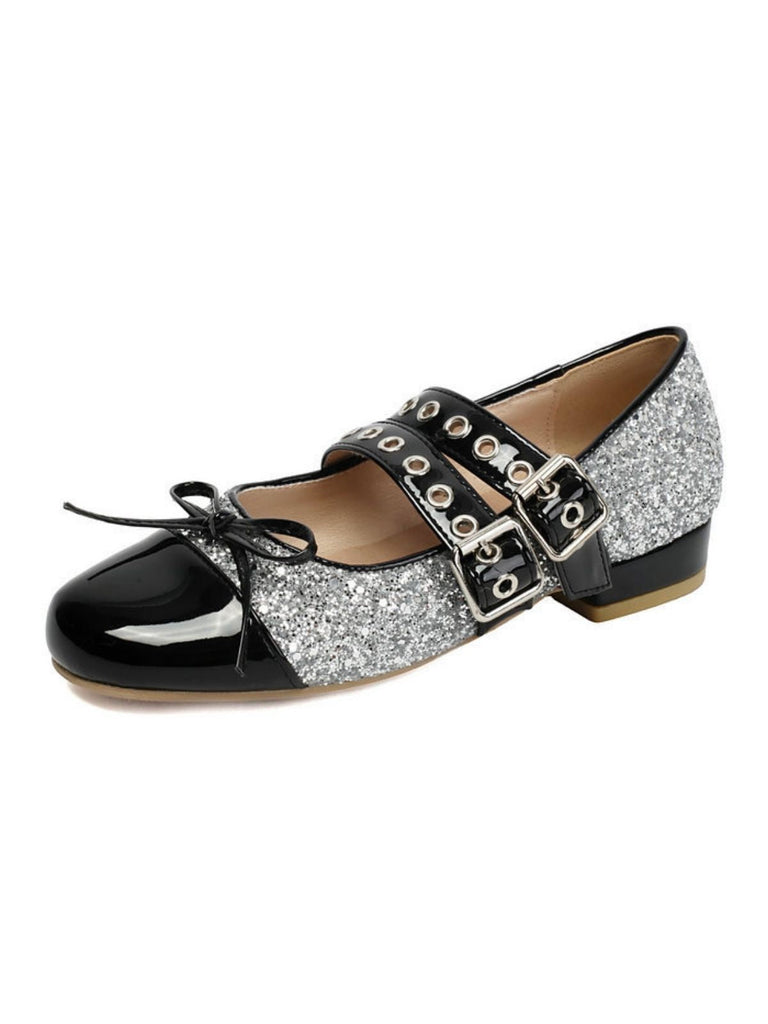 Chaussure plate noire et argentée à paillettes avec boucles sur fond blanc