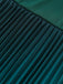 Close-up of pleated teal fabric with a blurred background