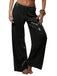 Pantalon à paillettes noires porté par une personne sur fond blanc