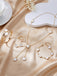White jewelry set with rings, bracelet, and necklace on a beige fabric background