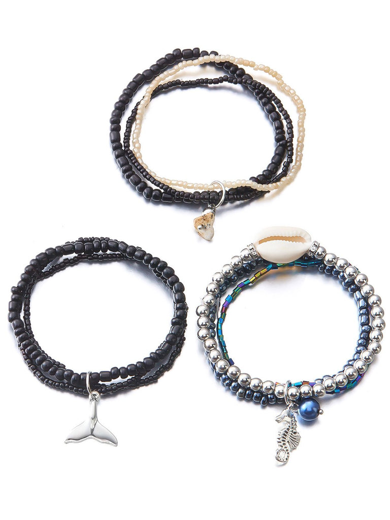 Three beaded bracelets with charms on a white background
