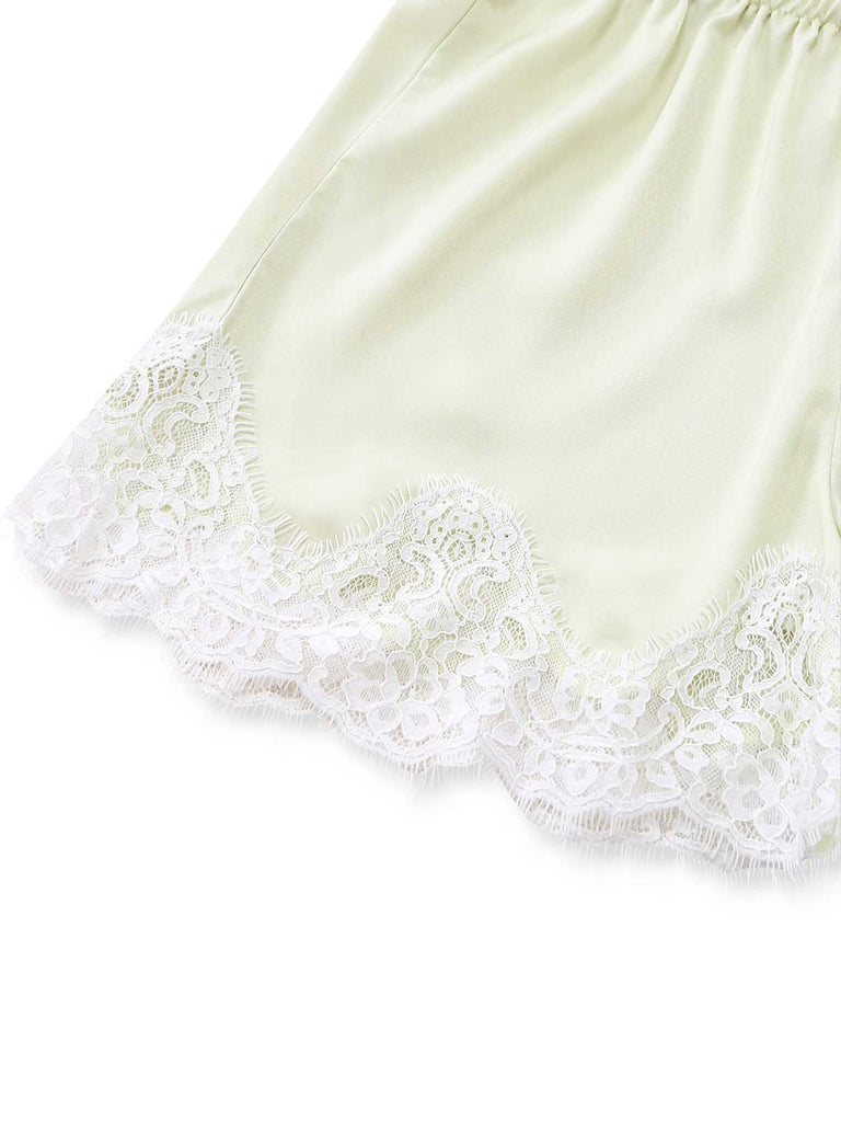 Detailed shot of the intricate white floral lace patterns along the hem of the shorts.